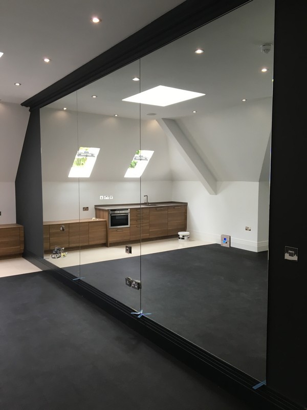 Frameless glass partition in loft conversion by Hanwell glaziers