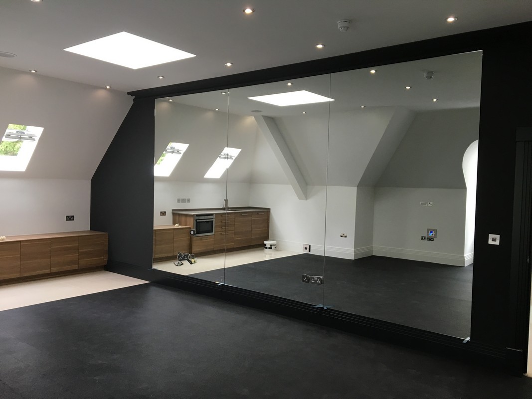 Frameless glass wall dividing loft conversion in Hanwell